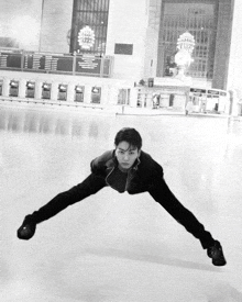 a black and white photo of a man on a ice rink in front of a sign that says ' boston central station '