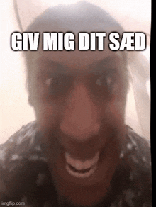 a close up of a person 's face with the words giv mig dit saed written above it