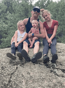 a family poses for a picture on a rock