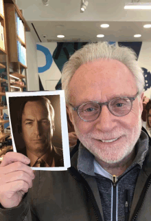 a man holding up a picture of a man with a beard