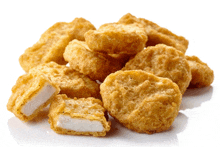 a pile of chicken nuggets with one missing a piece