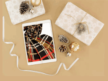 a tablet with a plaid scarf on the screen is surrounded by christmas decorations