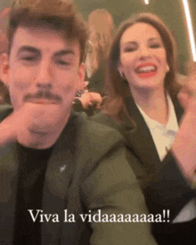 a man with a mustache and a woman laughing with the words viva la vida written below them .