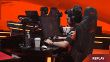 a man sits in a chair that says " replay " on it