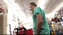 a man in a green scrub top is standing in a store with a sign that says energy