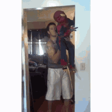 a man is carrying a child in a spiderman costume .