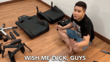 a man sitting on the floor with the words wish me luck guys on the bottom