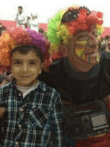 a man in a clown costume is posing for a picture with a boy wearing a plaid shirt .