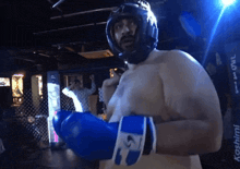 a man wearing boxing gloves and a helmet stands in front of a sign that says kashii