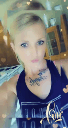 a woman with a tattoo on her chest is wearing a black tank top that says love