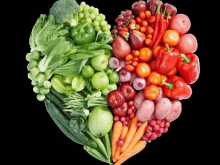 a heart made of fruits and vegetables with a black background