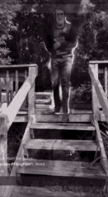 a man is standing on a set of wooden stairs .