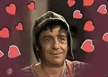 a man wearing a hat is smiling surrounded by hearts