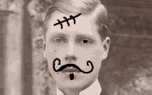 a man with a cross on his forehead and a mustache .