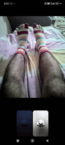 a phone screen shows a picture of a person 's feet with striped socks