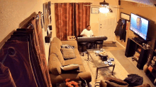 a man playing a keyboard in a living room with the word kasa written on the wall