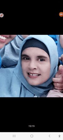 a woman wearing a hijab is smiling for the camera