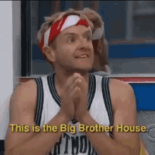 a man wearing a headband and a basketball jersey is sitting in a locker room with his hands folded .