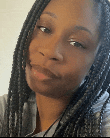 a woman with braids is smiling for the camera