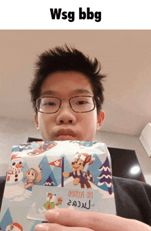 a boy wearing glasses is holding a christmas present that says wsg bbc