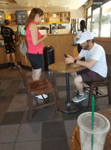 a man sits at a table looking at his phone