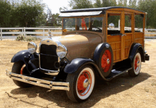 an old woody station wagon is parked in a dry field