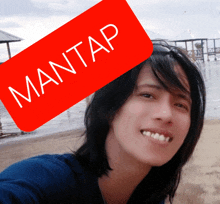 a woman is smiling with a red sticker that says mantap over her head