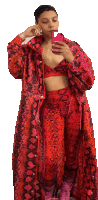 a woman taking a picture of herself in a red snakeskin outfit