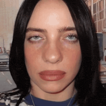 a close up of a woman 's face with a striped shirt on
