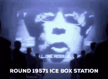 a group of people looking at a screen that says round 19571 ice box station on it