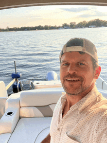 a man wearing a baseball cap is sitting on a boat