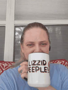 a woman drinking from a mug that says lizzid peeple