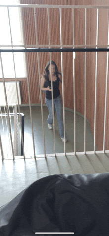 a woman in a black tank top is standing in a room