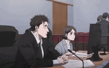 a man and a woman are sitting at a table with a microphone in front of them .