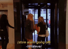 two women are walking out of an elevator with the words store alarm going off whatever