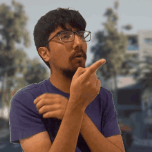 a man with glasses and a beard is making a gesture with his finger