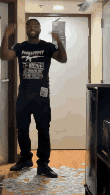 a man wearing a black shirt that says phenomnt is dancing