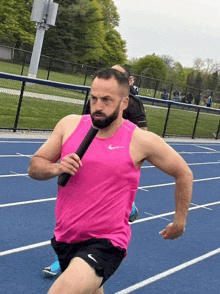 a man running on a track holding a baton