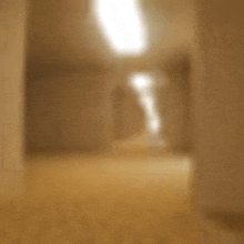 a blurred image of a hallway with a light coming through the ceiling .