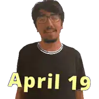 a man wearing glasses and a black shirt with april 19 written on it