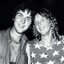 a black and white photo of a man and a woman standing next to each other .