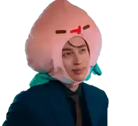 a man in a suit and tie is wearing a peach hat on his head
