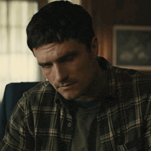 a man in a plaid shirt is looking up