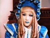 a woman wearing a blue dress and blue hat