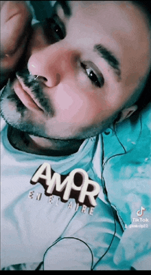 a man with a beard wearing a shirt that says amor