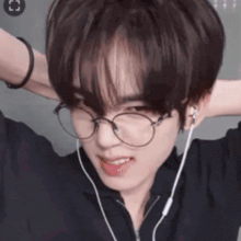 a young man wearing glasses and headphones is smiling .