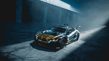 a black and gold race car is parked in a dark room