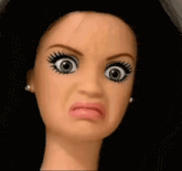 a close up of a doll 's face making a face
