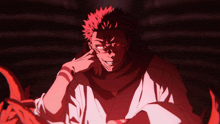 a man with red hair and red eyes is smiling in a dark room