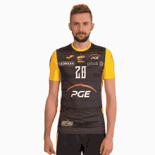 a man wearing a black and yellow shirt that says pge